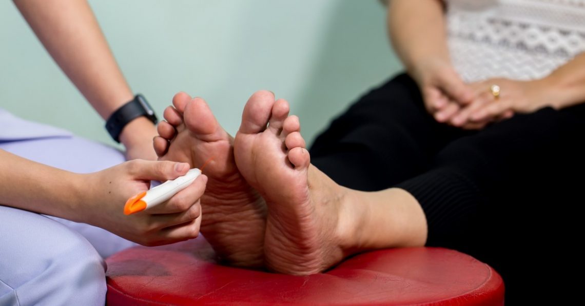 an image of a patient's feet being tested for nerve response