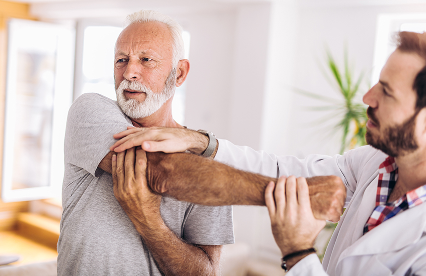 older man being looked at by a spine doctor